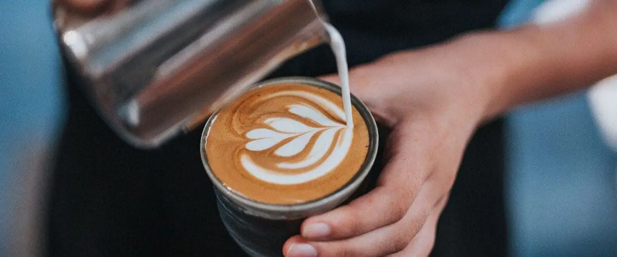Latte being poured into cup