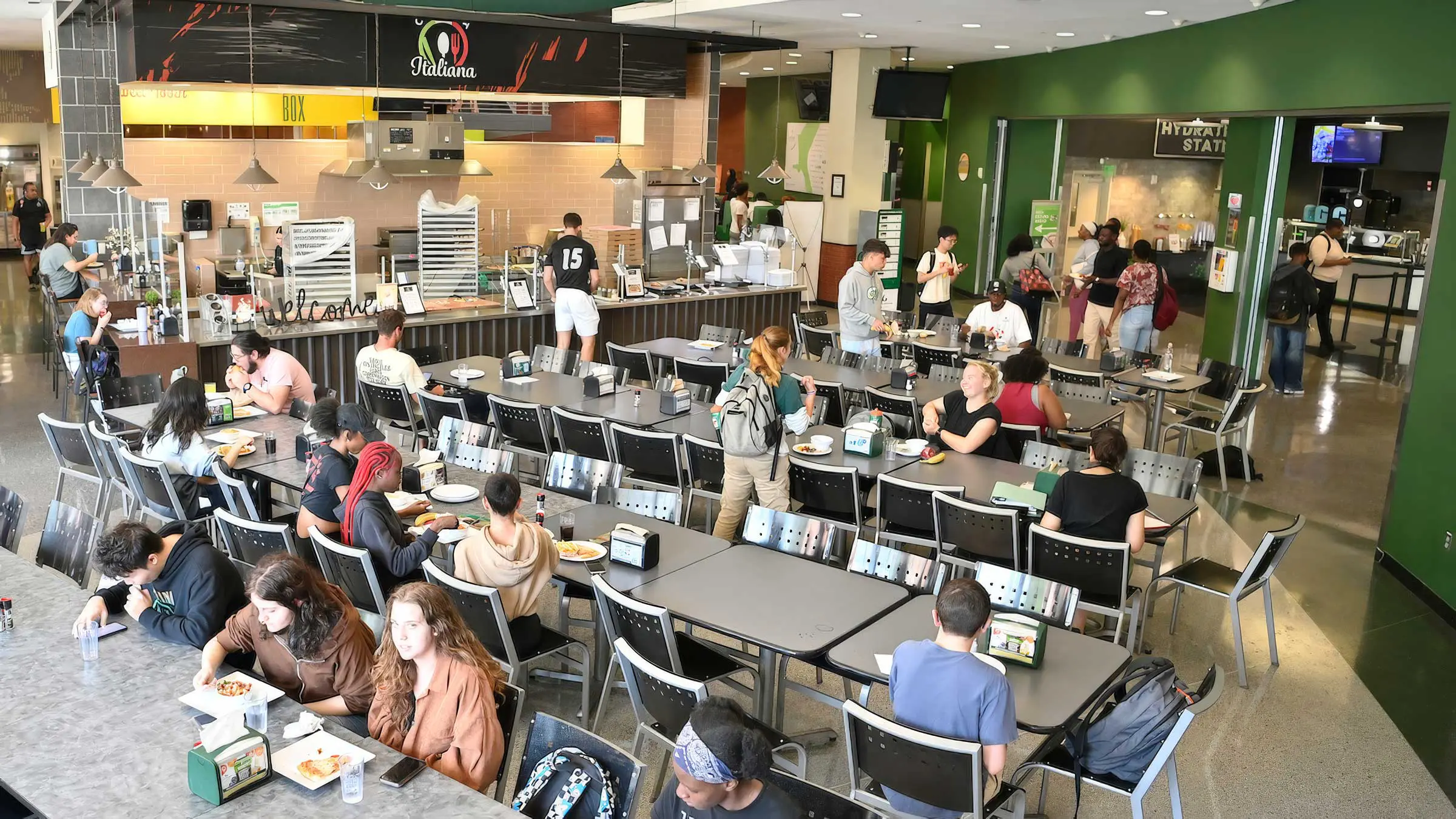 View of dining hall with tables and students having meal