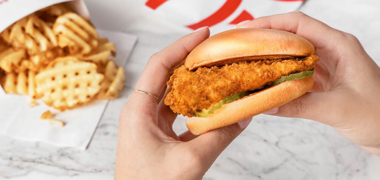 Hands holding chicken sandwich